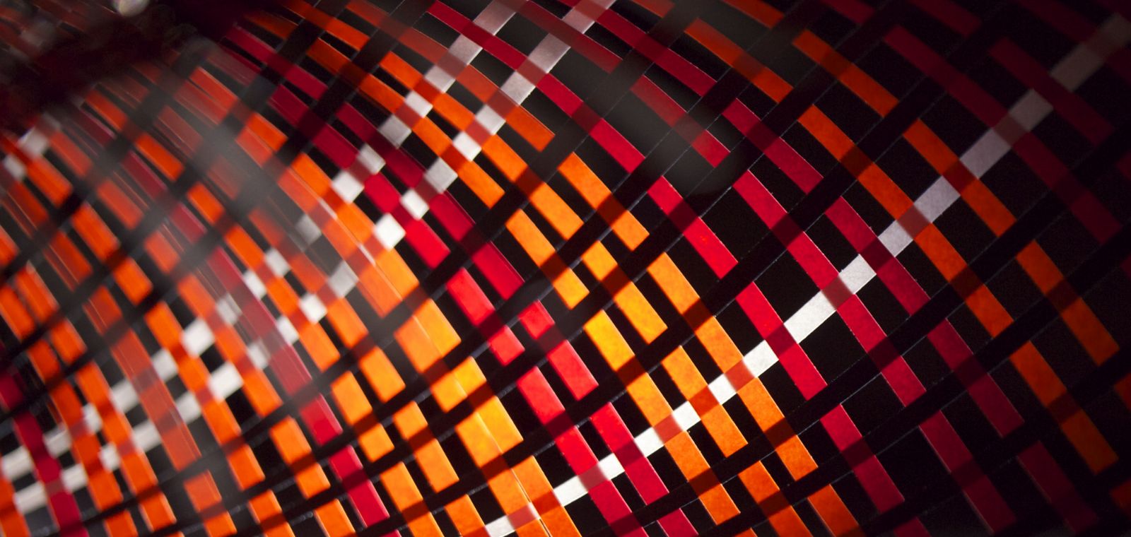 Diagonal open weave multicolored paper strips form a tunnel effect